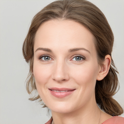 Joyful white young-adult female with medium  brown hair and grey eyes