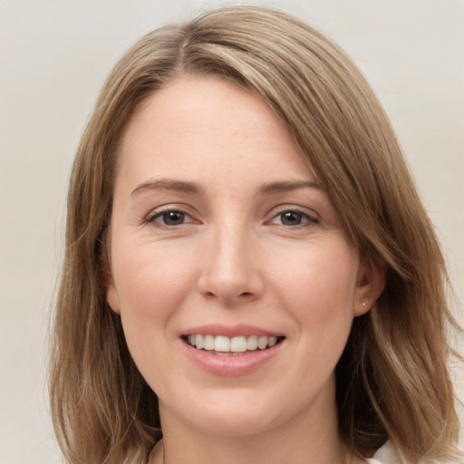 Joyful white young-adult female with long  brown hair and grey eyes