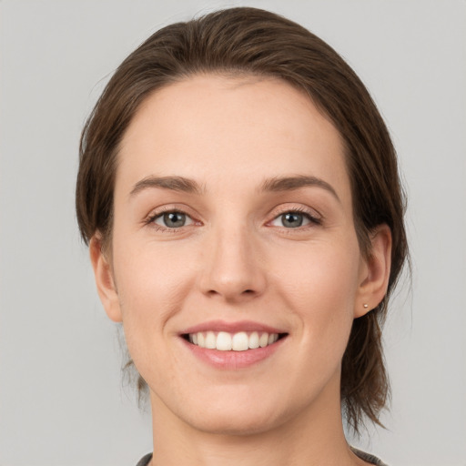 Joyful white young-adult female with medium  brown hair and green eyes