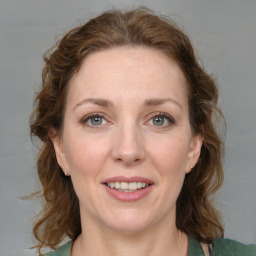 Joyful white adult female with medium  brown hair and blue eyes