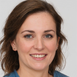 Joyful white young-adult female with medium  brown hair and grey eyes