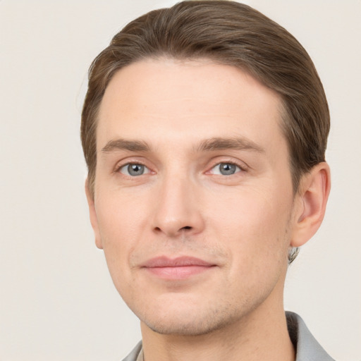 Joyful white young-adult male with short  brown hair and grey eyes