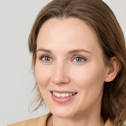 Joyful white young-adult female with medium  brown hair and blue eyes