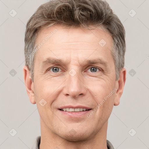 Joyful white adult male with short  brown hair and grey eyes