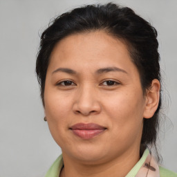 Joyful latino adult female with medium  brown hair and brown eyes