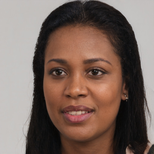 Joyful black young-adult female with long  black hair and brown eyes