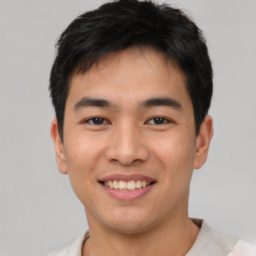 Joyful asian young-adult male with short  brown hair and brown eyes