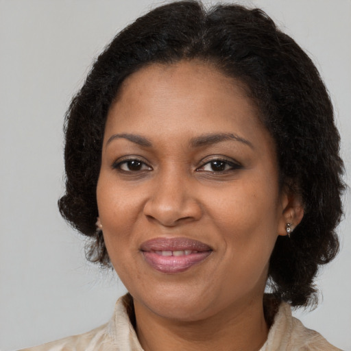 Joyful black adult female with medium  brown hair and brown eyes