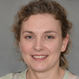 Joyful white adult female with medium  brown hair and blue eyes