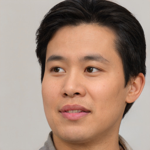 Joyful asian young-adult male with short  brown hair and brown eyes