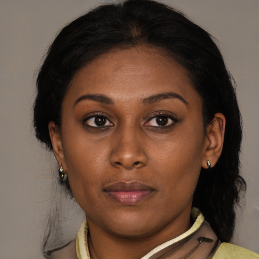 Joyful black young-adult female with medium  brown hair and brown eyes