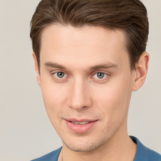 Joyful white young-adult male with short  brown hair and grey eyes