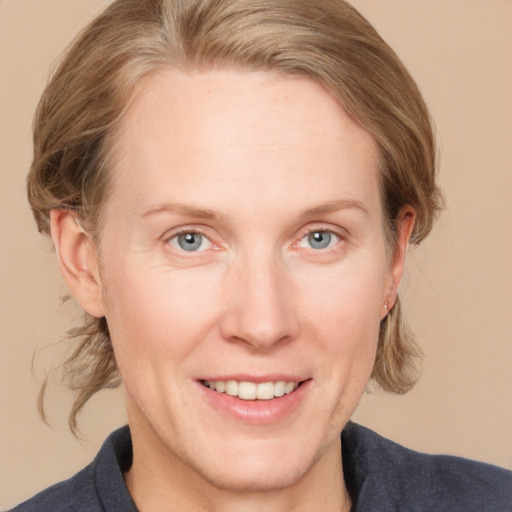 Joyful white adult female with medium  brown hair and blue eyes