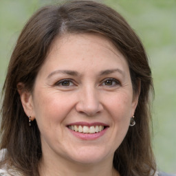 Joyful white adult female with medium  brown hair and grey eyes