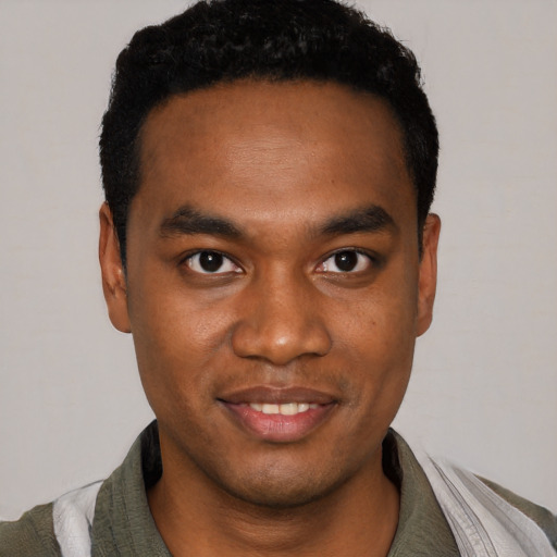 Joyful black young-adult male with short  black hair and brown eyes