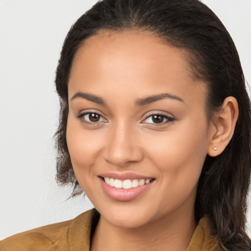 Joyful latino young-adult female with long  brown hair and brown eyes