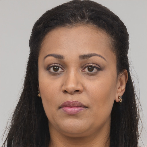 Joyful black young-adult female with long  brown hair and brown eyes