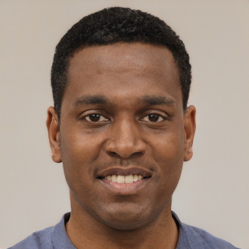 Joyful black young-adult male with short  black hair and brown eyes