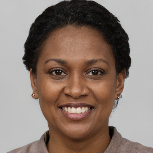 Joyful black young-adult female with short  brown hair and brown eyes