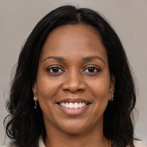 Joyful black young-adult female with long  brown hair and brown eyes