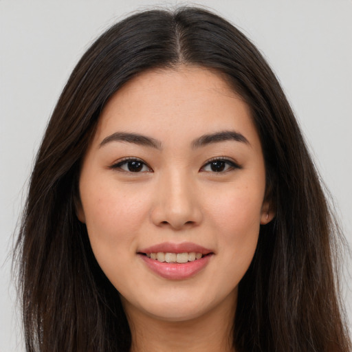 Joyful asian young-adult female with long  brown hair and brown eyes