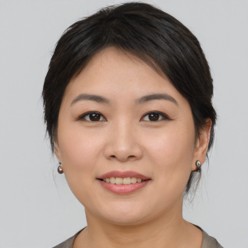 Joyful asian young-adult female with medium  brown hair and brown eyes