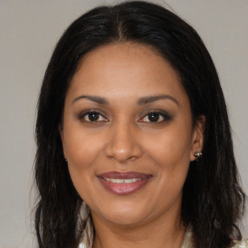 Joyful black adult female with long  brown hair and brown eyes