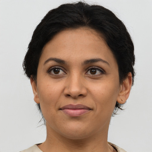 Joyful latino adult female with medium  brown hair and brown eyes