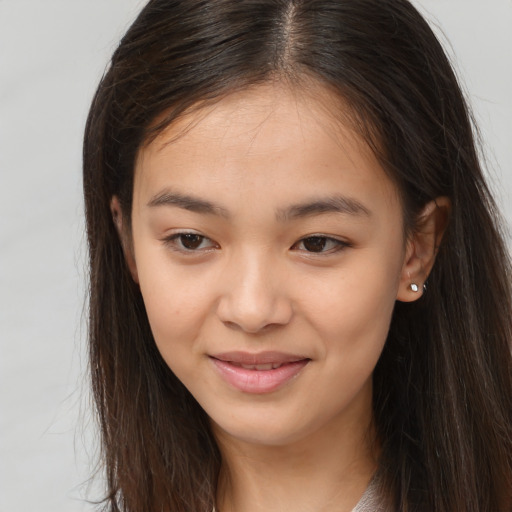 Joyful asian young-adult female with long  brown hair and brown eyes