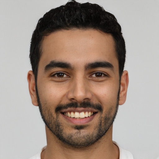 Joyful latino young-adult male with short  black hair and brown eyes