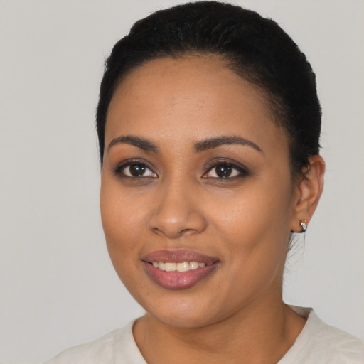 Joyful latino young-adult female with short  black hair and brown eyes