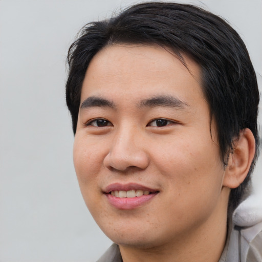 Joyful asian young-adult male with medium  black hair and brown eyes
