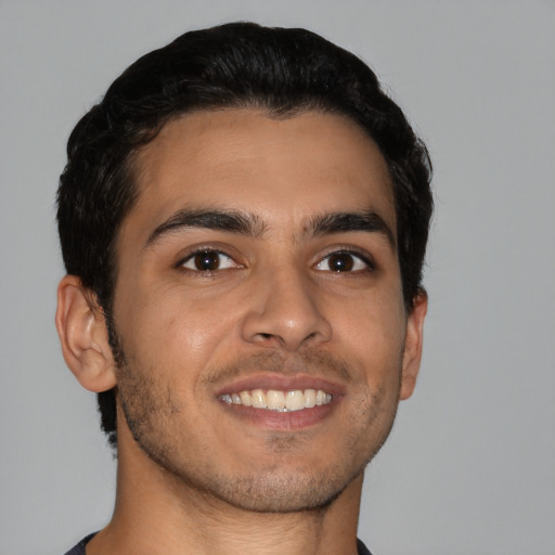 Joyful latino young-adult male with short  brown hair and brown eyes