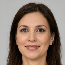 Joyful white adult female with long  brown hair and brown eyes