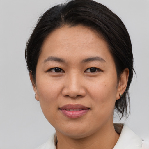 Joyful asian adult female with medium  brown hair and brown eyes