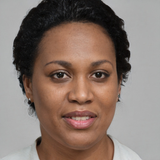 Joyful black adult female with short  black hair and brown eyes