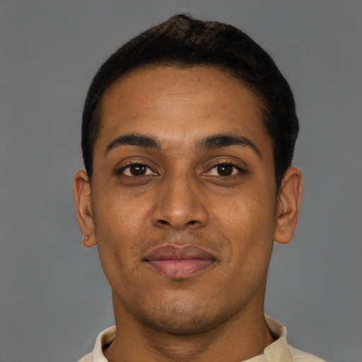 Joyful black young-adult male with short  brown hair and brown eyes