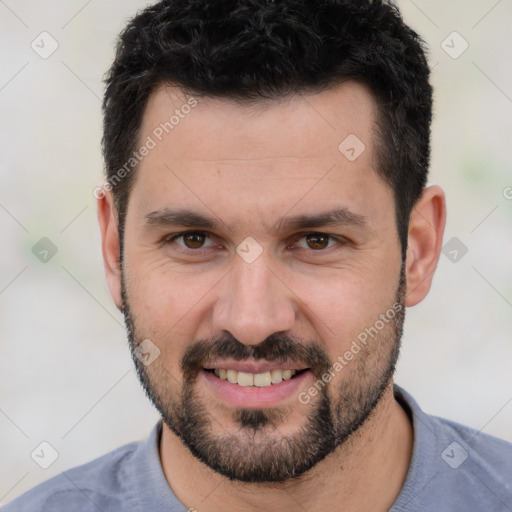 Joyful white young-adult male with short  black hair and brown eyes