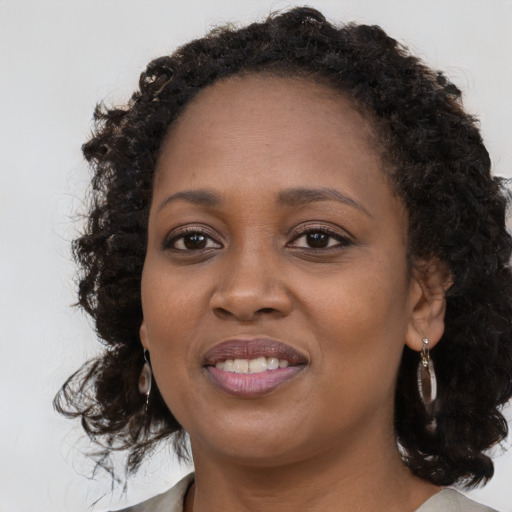 Joyful black young-adult female with medium  brown hair and brown eyes