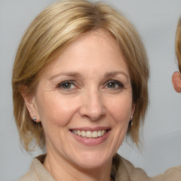 Joyful white adult female with medium  brown hair and blue eyes