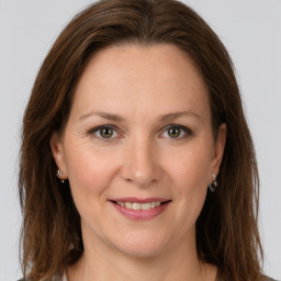 Joyful white adult female with long  brown hair and grey eyes