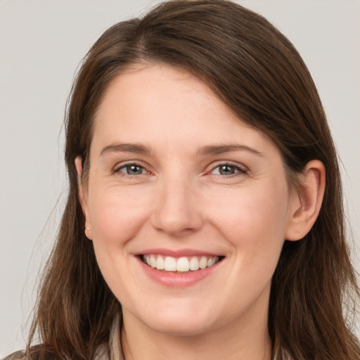 Joyful white young-adult female with long  brown hair and grey eyes