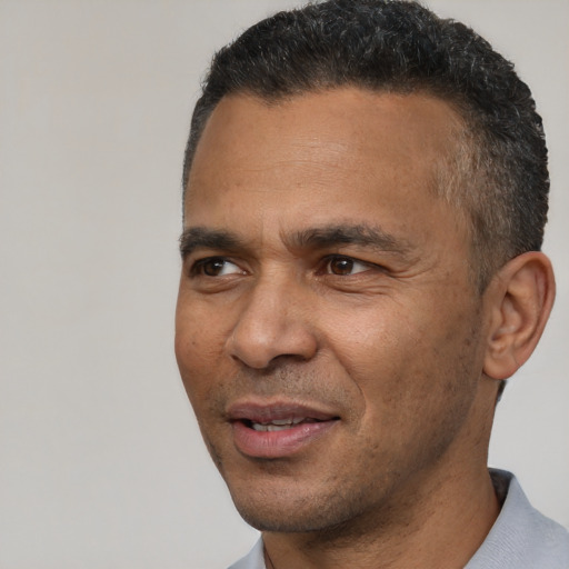 Joyful latino adult male with short  black hair and brown eyes