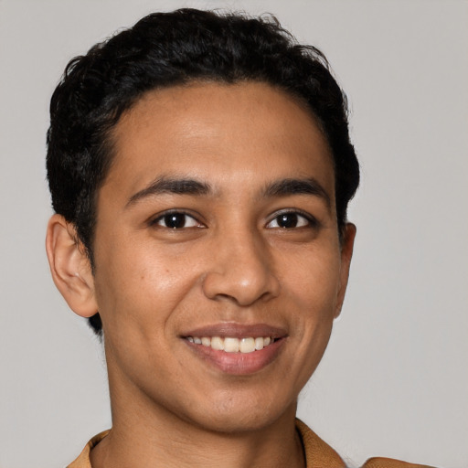 Joyful latino young-adult male with short  brown hair and brown eyes