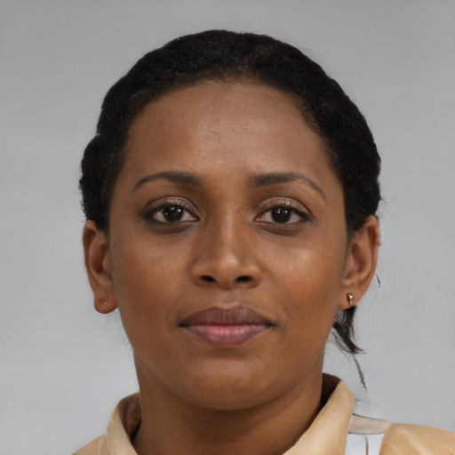 Joyful black young-adult female with short  brown hair and brown eyes
