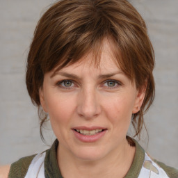 Joyful white adult female with medium  brown hair and blue eyes