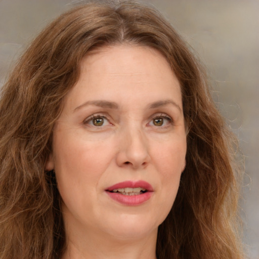 Joyful white adult female with long  brown hair and green eyes