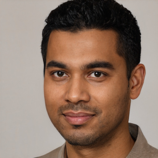 Joyful black young-adult male with short  black hair and brown eyes