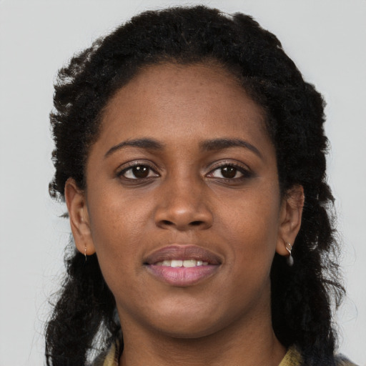 Joyful black young-adult female with long  black hair and brown eyes