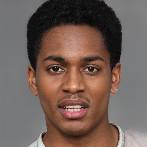 Joyful black young-adult male with short  black hair and brown eyes